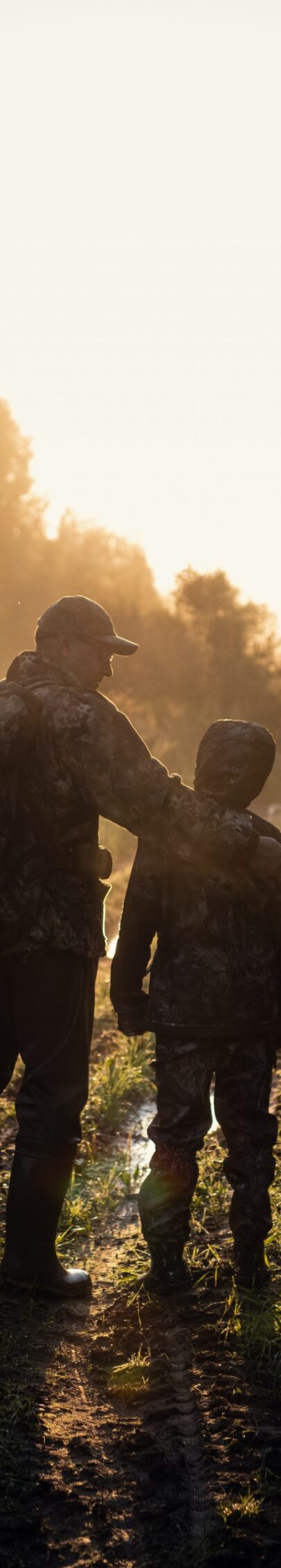 father pointing and guiding son on first deer hunt.